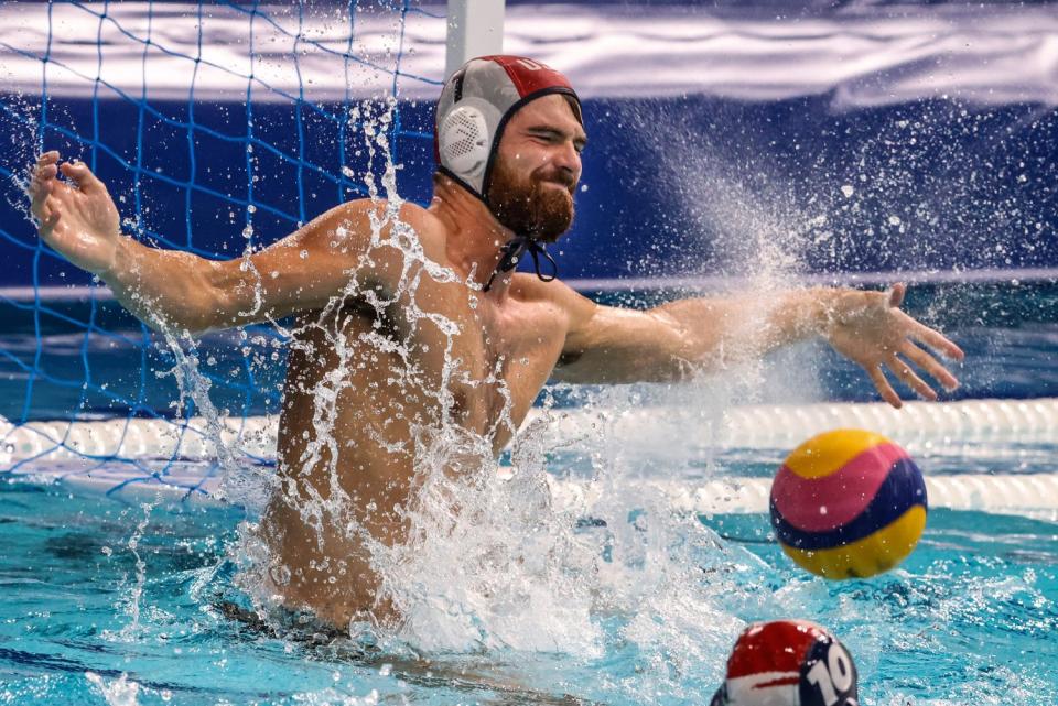 Goalkeeper Alex Wolf deflects the ball for the U.S. during water polo at the Tokyo Olympics.