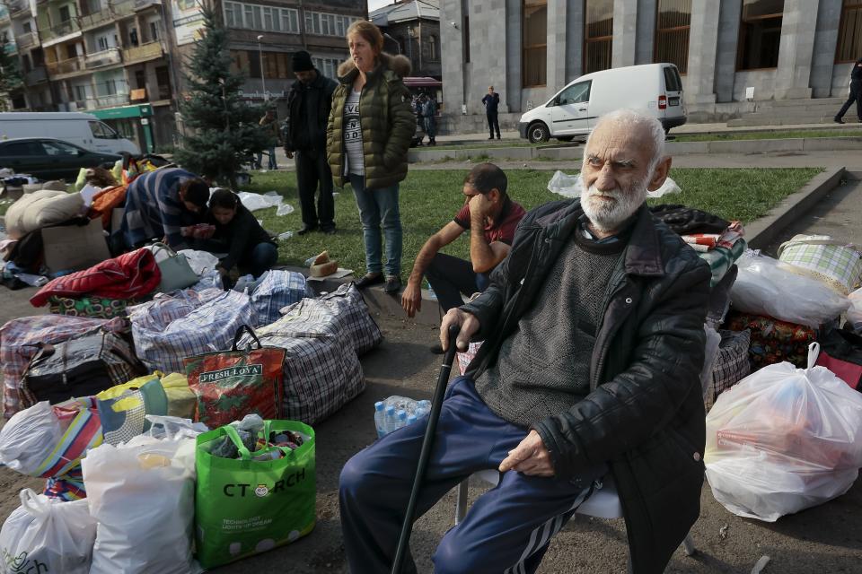 Ethnic Armenians from Nagorno-Karabakh sit next to their belongings near a tent camp after arriving to Armenia's Goris in Syunik region, Armenia, on Saturday, Sept. 30, 2023. Armenian officials say that by Friday evening over 97,700 people had left Nagorno-Karabakh. The region's population was around 120,000 before the exodus began. (AP Photo/Vasily Krestyaninov)