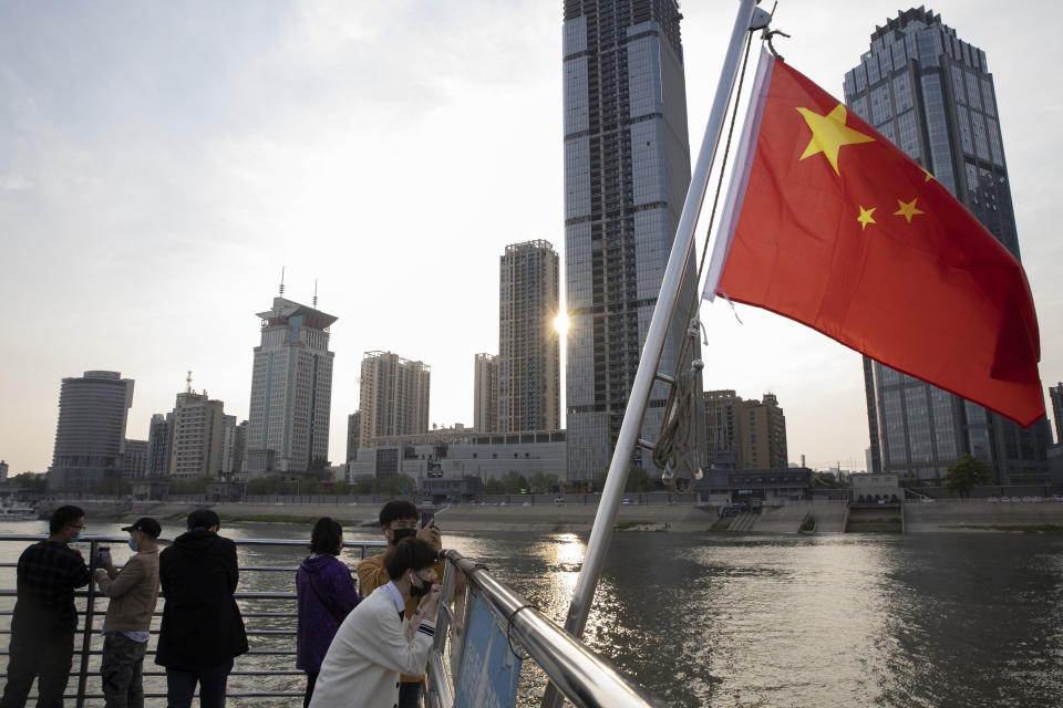 In this April 8, 2020, photo, passengers cross the Yangtze River on a ferry in Wuhan in central China's Hubei province. The reopening of ferry service on the Yangtze River, the heart of life in Wuhan for more than 20 centuries, was an important symbolic step in official efforts to get business and daily life in this central Chinese city of 11 million people back to normal after a 76-day quarantine ended in the city at the center of the coronavirus pandemic. (AP Photo/Ng Han Guan)