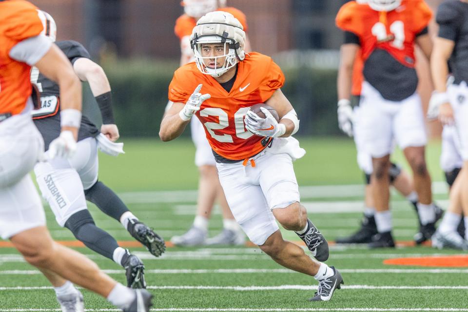 Oklahoma State freshman Sesi Vailahi runs with the ball during a preseason practice in August 2023.