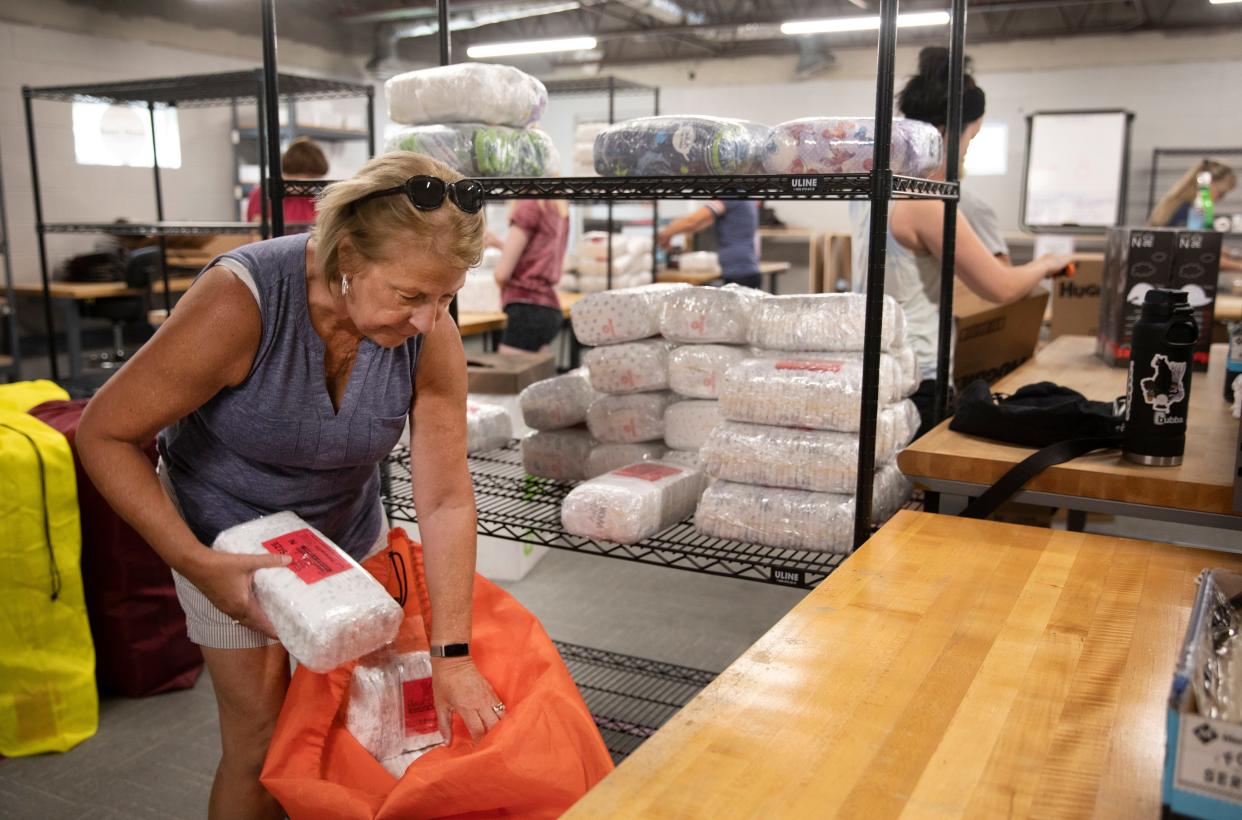 Jane Hamberg, of Delhi, gets diapers ready for distribution at Sweet Cheeks Diaper Bank in Lower Price Hill, July 20, 2021. Hamberg is the lead volunteer. Megan Fischer, CEO and founder, started the bank in 2015 in her basement when she realized the intense need for diapers in low-income households. Today they occupy 16,000 square feet and have become the biggest diaper bank in the country.  