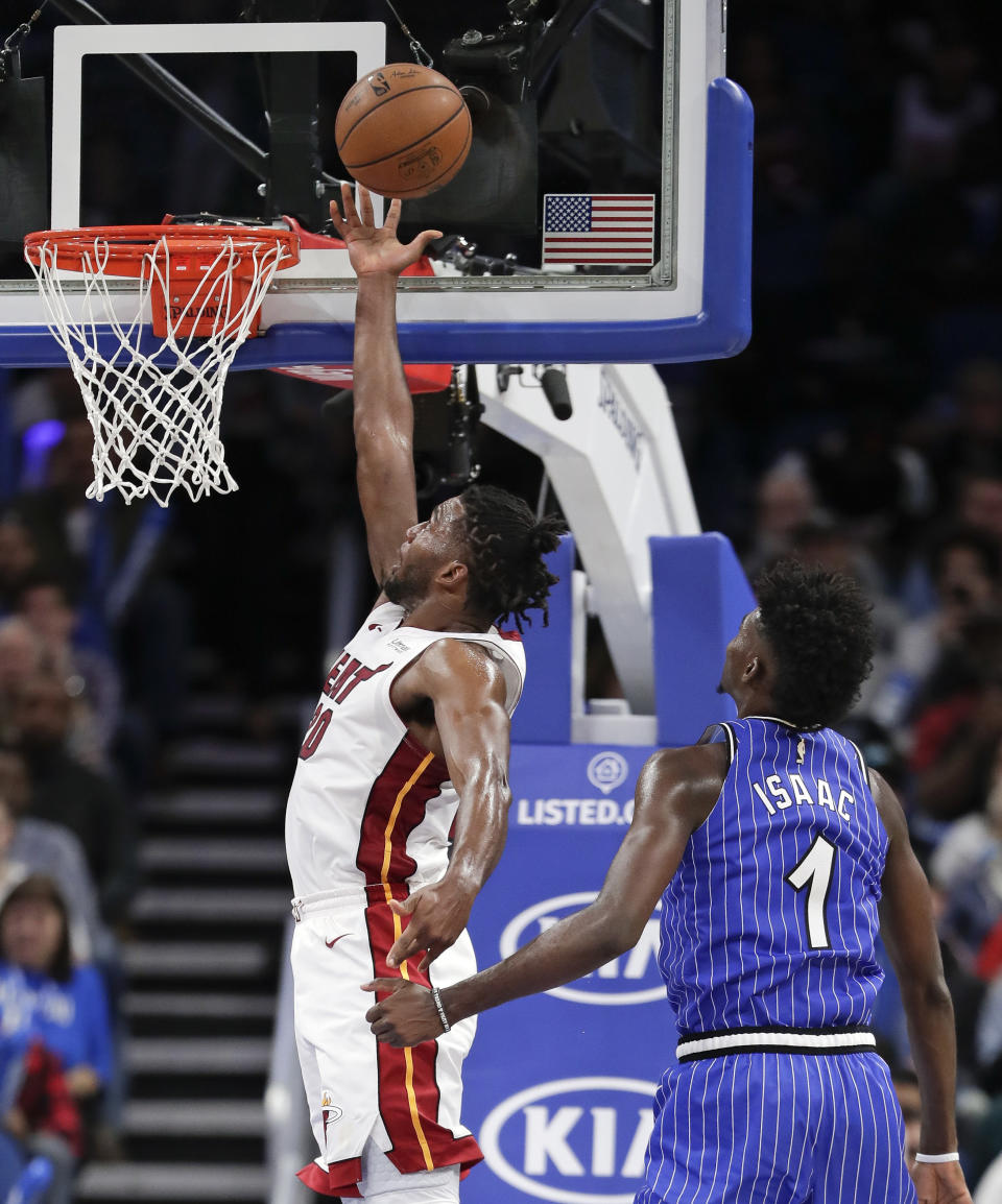 Miami Heat's Justise Winslow, left, goes past Orlando Magic's Jonathan Isaac (1) for a basket during the second half of an NBA basketball game, Sunday, Dec. 23, 2018, in Orlando, Fla. (AP Photo/John Raoux)