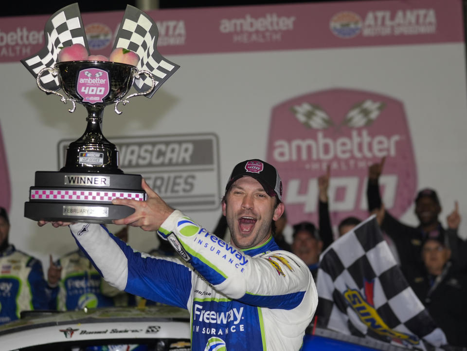 Daniel Suarez sostiene el trofeo tras ganar la carrera de la Cup Series de la NASCAR en Atlanta Motor Speedway el domingo 25 de febrero del 2024. (AP Foto/John Bazemore)