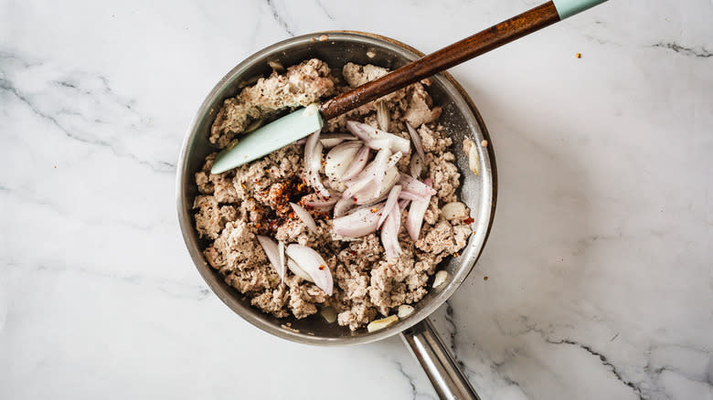 Turkey, shallots and seasonings in pan with spatula