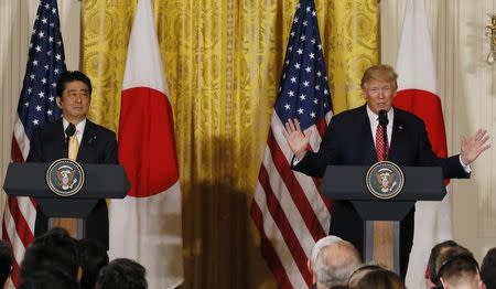 FILE PHOTO: Japanese Prime Minister Shinzo Abe (L) looks on as U.S. President Donald Trump speaks during a joint press conference at the White House in Washington, U.S., February 10, 2017. REUTERS/Jim Bourg