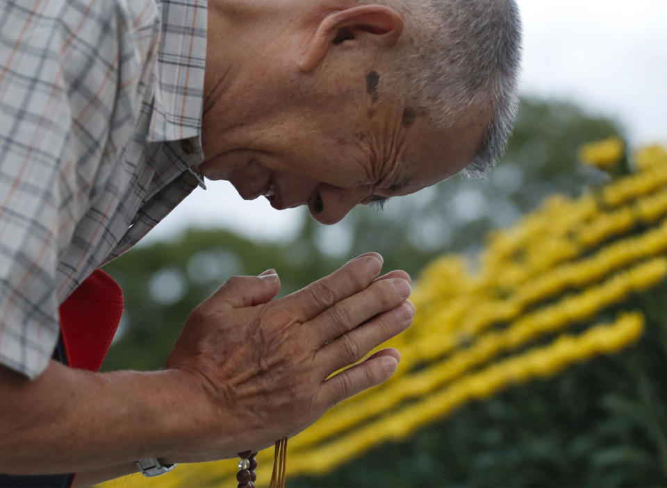 A man prays for the atomic bomb victims in front of the cenotaph at the Hiroshima Peace Memorial Park in Hiroshima, western Japan during a ceremony to mark the 74th anniversary of the bombing Tuesday, Aug. 6, 2019. (Kyodo News via AP)