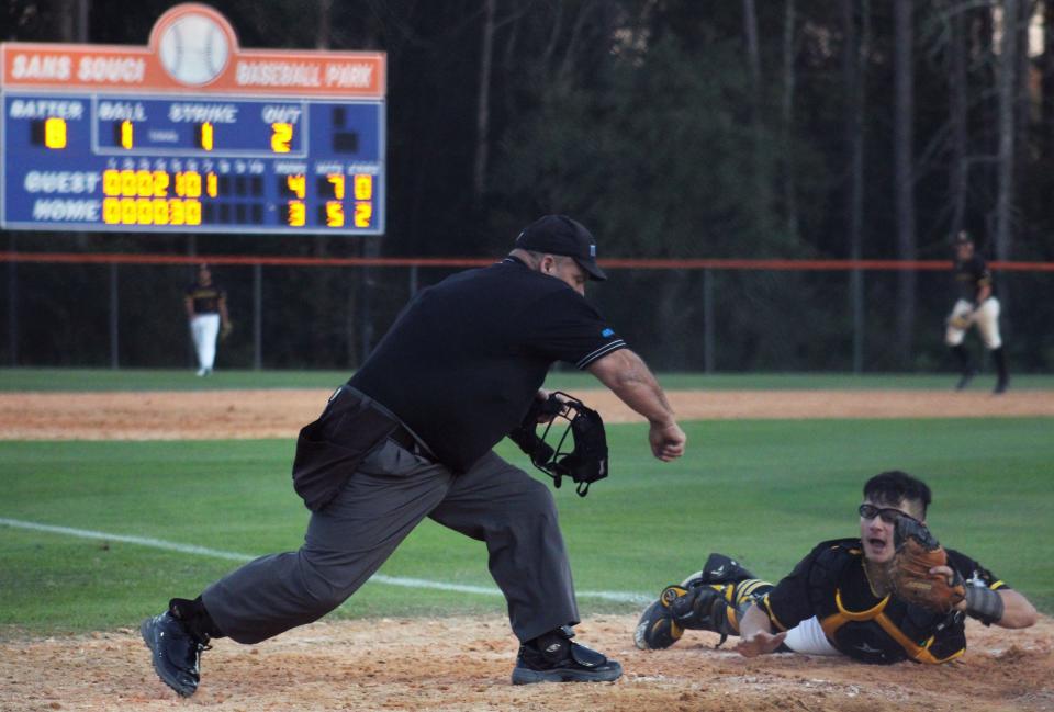 Englewood catcher Dominick Patruno (right) shows the ball from the tag as the home plate umpire signals an out at the plate during the Walk Off Charities Baseball Classic against Yulee at Sans Souci Baseball Park on February 13, 2023. [Clayton Freeman/Florida Times-Union]