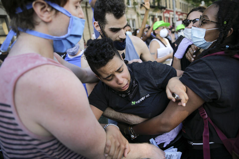 Protesters react during a demonstration Saturday, May 30, 2020, in the Brooklyn borough of New York. Protests were held throughout the city over the death of George Floyd, a black man who was in police custody in Minneapolis. Floyd died after being restrained by Minneapolis police officers on Memorial Day. (AP Photo/Seth Wenig)