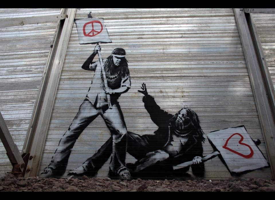 GLASTONBURY, ENGLAND - JUNE 24:  Art work said to be by underground artist Banksy is seen on the fence at the Glastonbury Festival site at Worthy Farm, Pilton on June 24, 2010 in Glastonbury, England. The gates opened yesterday to what has become Europe's largest music festival and is celebrating its 40th anniversary. (Photo by Matt Cardy/Getty Images)