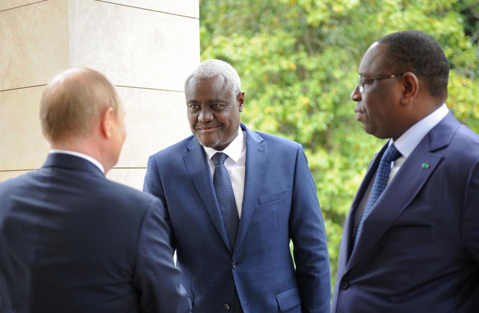 Russian President Vladimir Putin, left back to a camera, speaks greets African Union Commission Chairperson Moussa Faki Mahamat, center, and Senegalese President and the chairman of the African Union Macky Sall during their meeting in the Bocharov Ruchei residence in the Black Sea resort of Sochi, Russia, Friday, June 3, 2022. (Mikhail Klimentyev, Sputnik, Kremlin Pool Photo via AP)