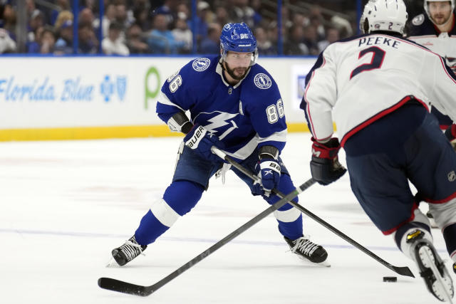 Tampa Bay Lightning right wing Nikita Kucherov (86) moves the puck around Columbus Blue Jackets defenseman Andrew Peeke (2) during the second period of an NHL hockey game Thursday, Dec. 15, 2022, in Tampa, Fla. (AP Photo/Chris O'Meara)