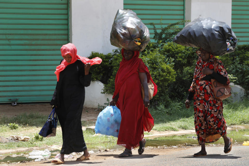 Sudanese women carry on their heads big bags of empty plastic bottles, as they walk on the street, in Khartoum, Sudan, Saturday, June 15, 2019. The top U.S. diplomat to Africa says there needs to be an "independent and credible" investigation into the Sudanese military's violent dispersal of a protest camp in Khartoum last week. (AP Photo/Hussein Malla)