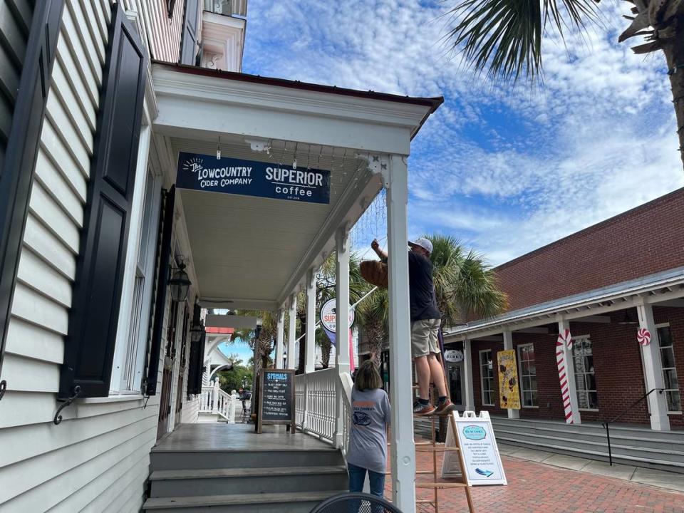 Abraham Saunderson and Hope Tolman remove plants from the porch at The Lowcountry Cide Company and Superior Coffee in Beaufort Tuesday morning in preparation for Hurricane Idalia, which is expeted to be a tropical storm by the time it reaches the city Wednesday.