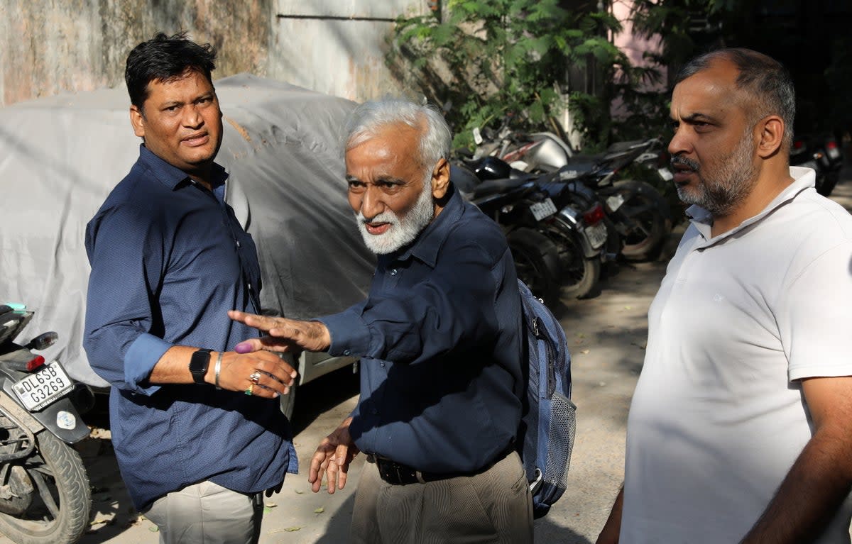 Journalist Urmilesh (centre), associated with NewsClick, gestures as he leaves the special cell police office in Lodhi Colony, New Delhi, on Tuesday (3 October) (EPA)