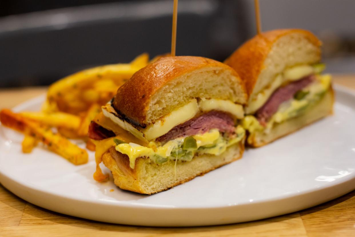 A fancy dish of a pastrami burger served with chips