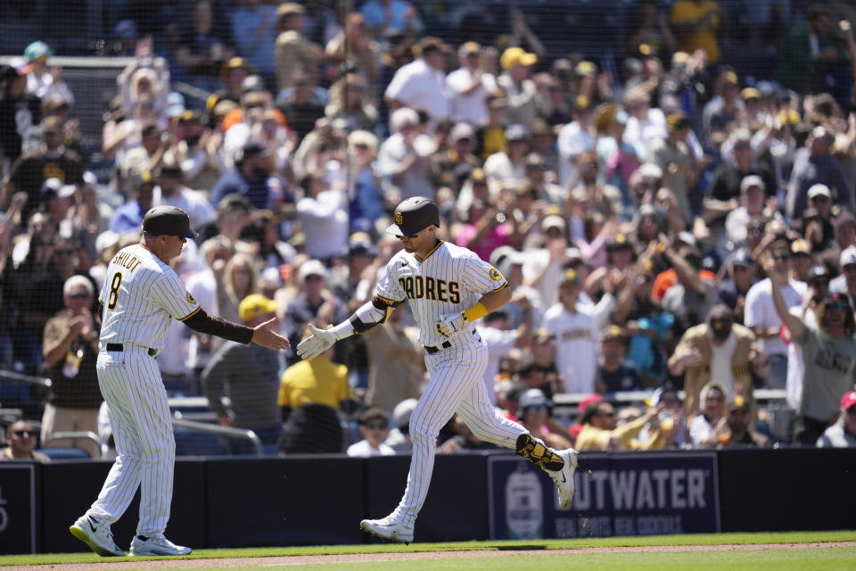 San Diego Padres' Brett Sullivan, right, is greeted by third base coach Jake Cronenworth after hitting a two-run home run during the fourth inning of a baseball game against the Cincinnati Reds, Wednesday, May 3, 2023, in San Diego. (AP Photo/Gregory Bull)