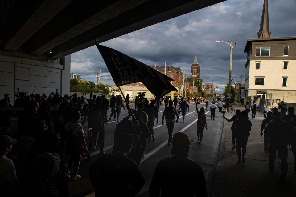 Protesters walk under an overpass as they march through downtown Louisville and into Nulu on Friday evening. Sept. 25, 2020