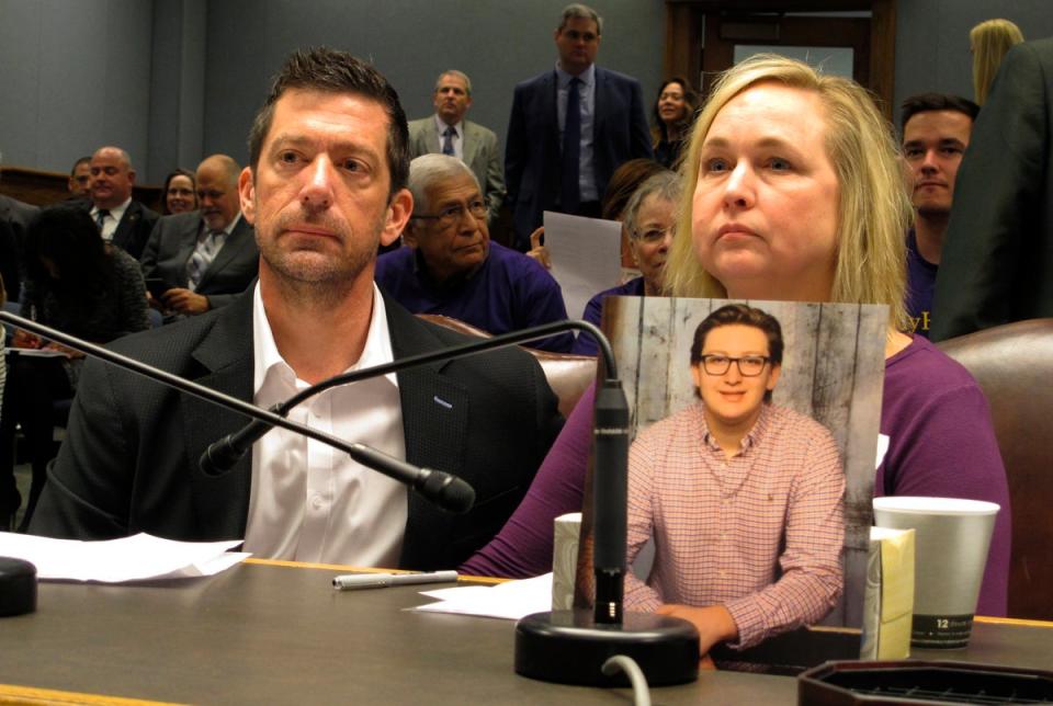 Stephen and Rae Ann Gruver with a photo of their son, Max, at a House committee room in Baton Rouge, Louisiana, in 2018 (AP)