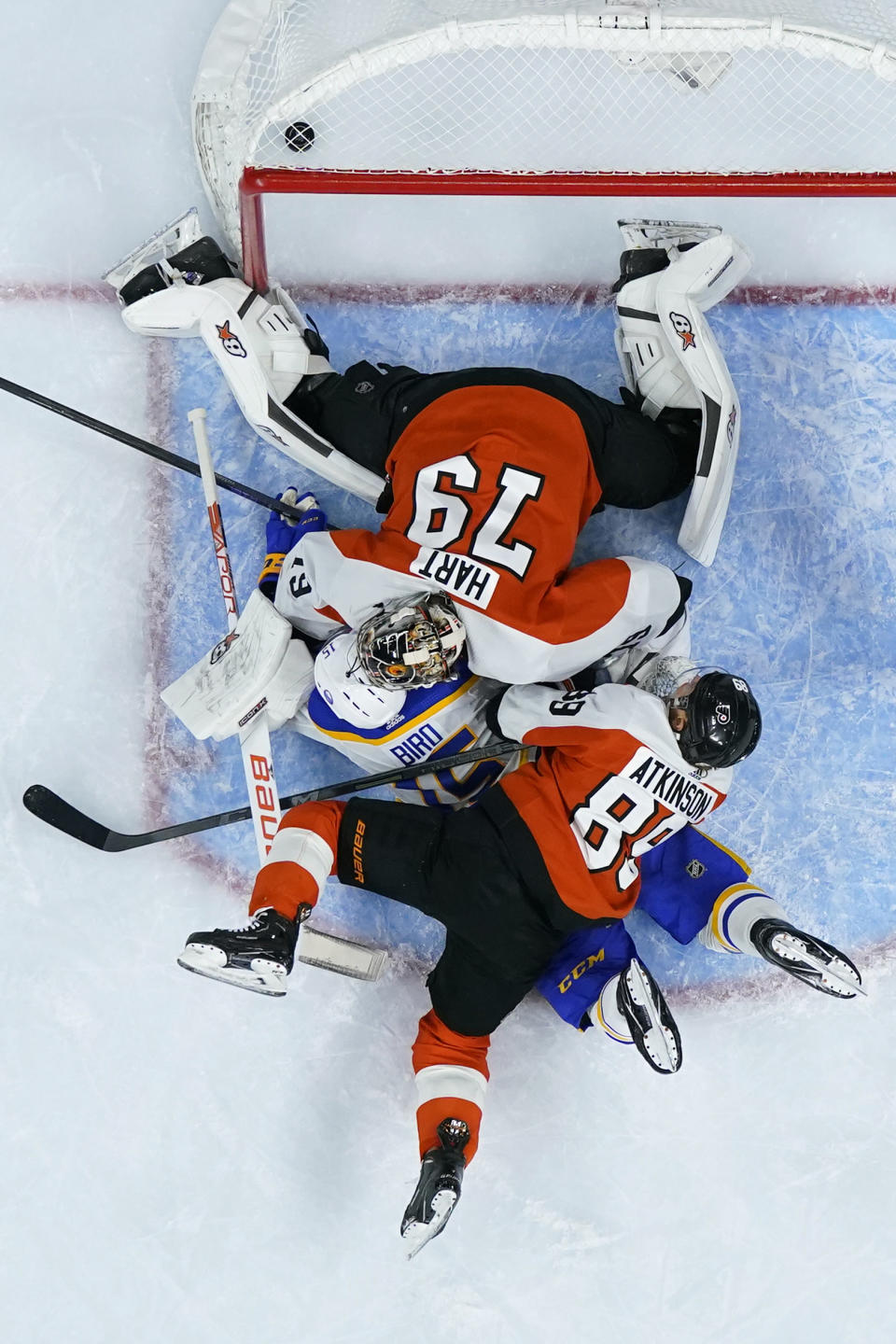 Buffalo Sabres' Brandon Biro, center, collides with Philadelphia Flyers' Carter Hart, top, and Cam Atkinson after scoring a goal during the first period of an NHL hockey game, Wednesday, Nov. 1, 2023, in Philadelphia. (AP Photo/Matt Slocum)