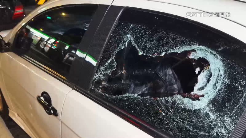 被砸的轎車後擋風玻璃破了兩個大洞，兩側的後車窗碎成蜘蛛網狀。