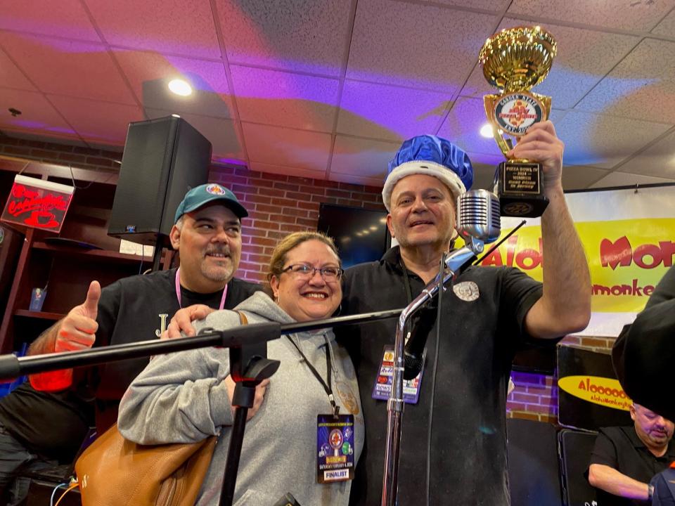 Jersey Pizza Joints Pizza Bowl winner Angelo Dalia, pizza maker at Vinnie's Mootz in Lyndhurst, sports his crown and hoists his Jersey Pizza Joints best pizza trophy for 2024. He is shown with Denise Morelli, the wife of Vinnie's Mootz owner Vinnie Morreli.