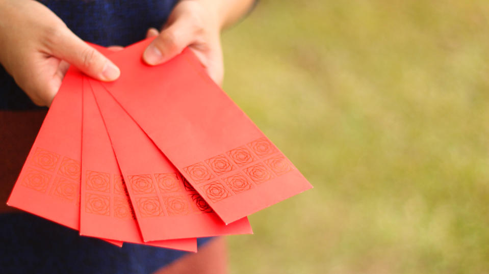 a Asian woman pick a red envelope. background for Chinese new year. lunar new year