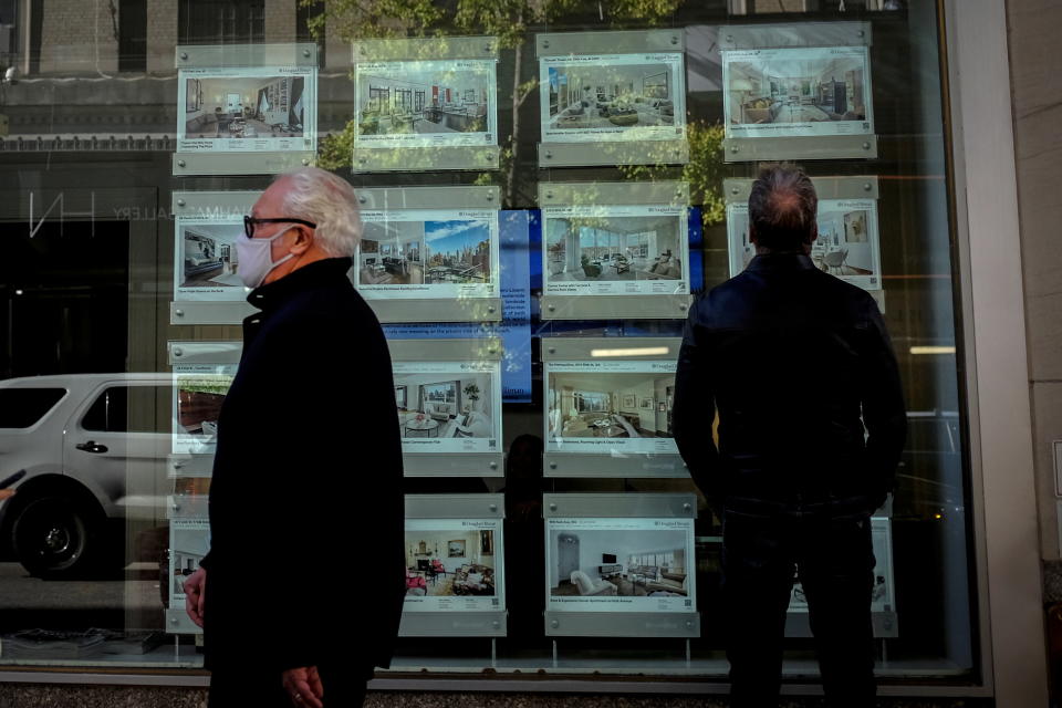 A man looks at advertisements for luxury apartments and homes in the window of a Douglas Elliman Real Estate sales business in Manhattan&#39;s upper east side neighborhood in New York City, New York. REUTERS/Mike Segar