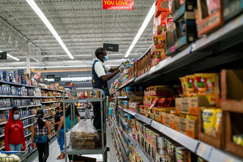 A worker and shoppers are seen wearing masks at a Walmart store, in North Brunswick, New Jersey