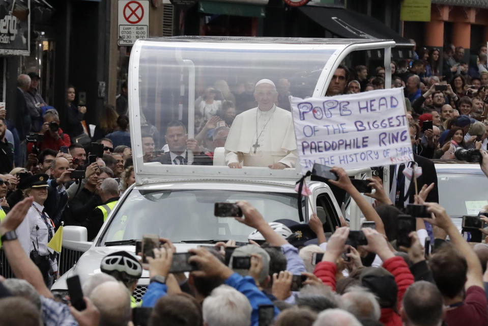 FILE - In this Saturday, Aug. 25, 2018 file photo Pope Francis passes by a banner of a protester as he leaves after visiting St Mary's Pro-Cathedral, in Dublin, Ireland. Pope Francis is on a two-day visit to Ireland. (AP Photo/Matt Dunham, File)