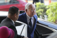 Former Malaysian Prime Minister Najib Razak, right, arrives at Kuala Lumpur High Court in Kuala Lumpur, Malaysia, Tuesday, Aug. 27, 2019. Malaysian prosecutors have wrapped up their case against Najib in his first corruption trial. Najib faces 42 charges of corruption, abuse of power and money laundering in five criminal cases linked to the multibillion-dollar looting of the 1MDB state investment fund. His second trial is due to begin Wednesday but could be delayed. Najib denies wrongdoing and accuses the new government of seeking political vengeance. (AP Photo/Vincent Thian)