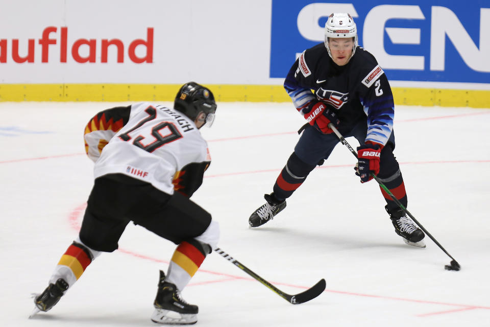 Germany's Dennis Lobach defends as United States' Jordan Harris carries the puck during the 2020 IIHF World Junior Ice Hockey Championships Group B match between Germany and USA in Ostrava, Czech Republic, Friday, Dec. 27, 2019. (Petr Sznapka/CTK via AP)