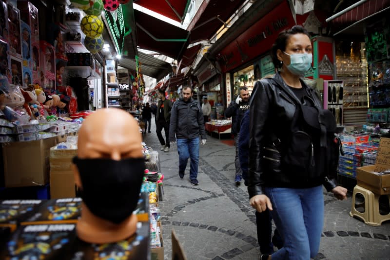 A woman wearing a protective face mask walks in a market at Eminonu neighbourhood during the outbreak of coronavirus disease (COVID-19), in Istanbul