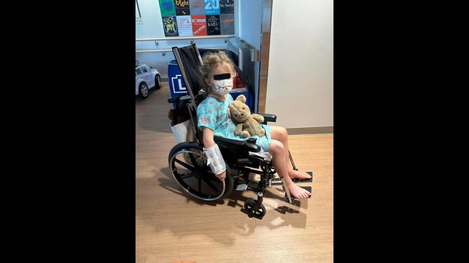 Emma, a 7-year-old Charlotte girl who was hospitalized for more than a week with an invasive group A strep infection in her leg, holds her stuffed animal, Teddy, as she learns how to use her wheelchair to move around Levine Children’s Hospital in Charlotte, in May 2023.