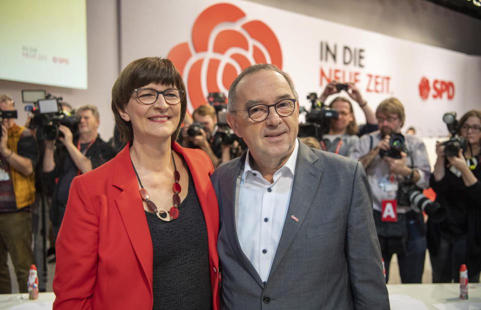 Norbert Walter-Borjans stands alongside Saskia Esken, from right, at the beginning of the German Social Democrats, SPD, federal party conference in Berlin, Germany, Friday, Dec. 6, 2019. Members of the center-left party have choosen the left-leaning duo Norbert Walter-Borjans and Saskia Esken as their new leaders. This has to be confirmed by the delegates at the party meeting. (Bernd von Jutrczenka/dpa via AP)