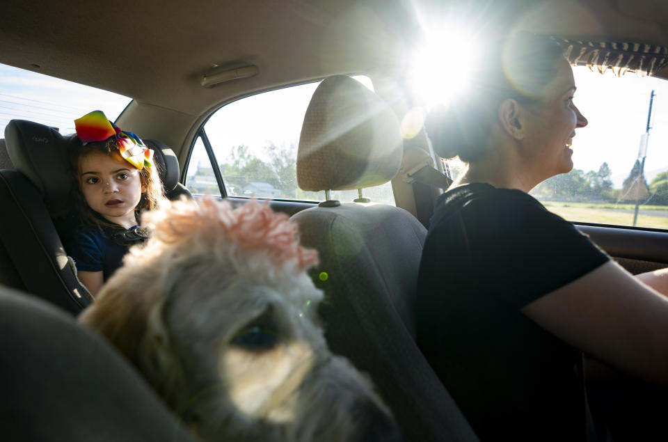 Scarlett Rasmussen, 8, looks on with service dog Riptide as her mother, Chelsea, drives them to Parkside Elementary School Wednesday, May 17, 2023, in Grants Pass, Ore. Chelsea fought for more than a year for her 8-year-old daughter, Scarlett, to attend full days at Parkside and says school employees told her the district lacked the staff to tend to Scarlett’s medical and educational needs, which the district denies. (AP Photo/Lindsey Wasson)