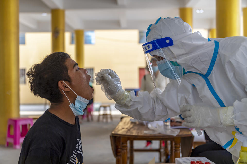 In this photo released by Xinhua News Agency, a resident receives nucleic acid testing for COVID-19 at Mengmao Village of Mengmao Township, Ruili City, southwestern China's Yunnan Province, March 31, 2021. COVID-19 cases in the southwestern Chinese city of Ruili bordering on Myanmar have now topped 100 on Monday, April 5, 2021. That comes as authorities have launched an aggressive campaign to vaccinate all 300,000 residents of the city, whose outbreak is something of an anomaly in a country that has all-but eliminated local transmission of the virus. (Chen Xinbo/Xinhua via AP)