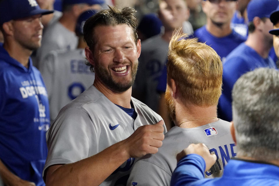 Los Angeles Dodgers starting pitcher Clayton Kershaw, left, hugs Justin Turner after the eighth inning of a baseball game against the Los Angeles Angels Friday, July 15, 2022, in Anaheim, Calif. (AP Photo/Mark J. Terrill)