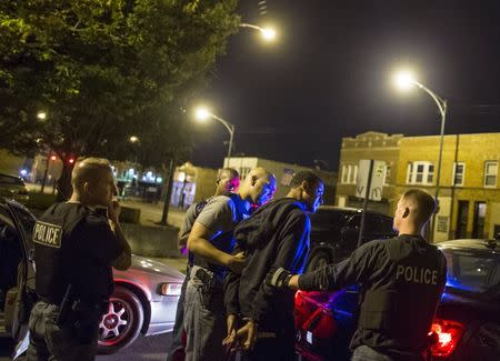 Cook County Sheriff police officers handcuff a man and take him into custody in the Austin neighborhood in Chicago, Illinois, United States, September 10, 2015. REUTERS/Jim Young