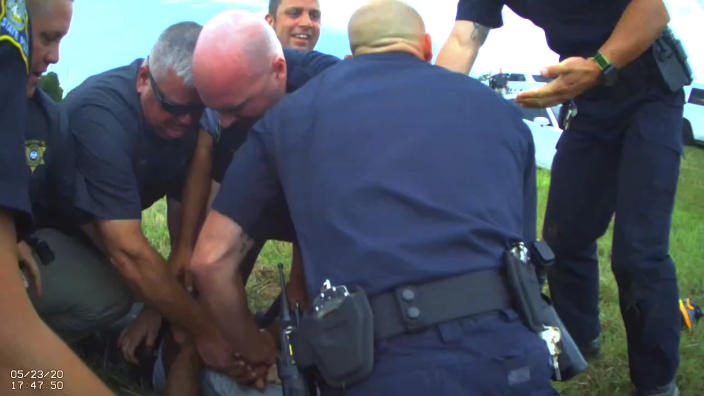 FILE - In this Saturday, May 23, 2020 image from Franklin Parish Sheriff's Office body camera video, law enforcement officers restrain Black motorist Antonio Harris, bottom center, on the side of a road after a high speed chase in Franklin Parish, La. State prosecutors have charged three former Louisiana State Police troopers, Jacob Brown, Dakota DeMoss and George “Kam” Harper, accused of beating Harris, hoisting him to his feet by his hair braids and bragging in text messages that the “whoopin'” would give him “nightmares for a long time.” (Aaron Touchet/Franklin Parish Sheriff's Office via AP, File)