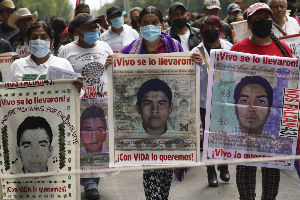 Familiares y amigos marchan en la Ciudad de M&#xe9;xico el viernes 26 de agosto de 2022 en busca de justicia para los 43 estudiantes de Ayotzinapa desaparecidos en 2014 en el estado de Guerrero. (AP Foto/Marco Ugarte)