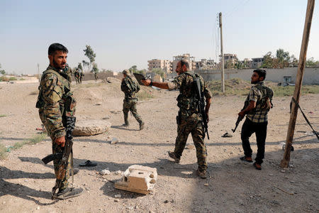 Members of the Syrian Democratic Forces walk at their position, during the fighting with Islamic State's fighters in Nazlat Shahada, a district of Raqqa, Syria August 16, 2017. REUTERS/Zohra Bensemra