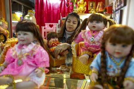 A "child angel" doll owner, Supattar Wichainan, 27, decorates her "child angel" dolls at her shop inside a department store in Bangkok, Thailand, January 26, 2016. REUTERS/Athit Perawongmetha