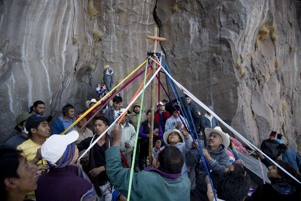 ARCHIVO - Los pobladores de las zonas cercanas celebran una ceremonia en una formación rocosa en la ladera del volcán Popocatépetl en México, el 12 de marzo de 2014. Cada 12 de marzo, personas de los pueblos que rodean al volcán Popocatépetl suben por sus laderas para hacer ofrendas y tocar música para pedirle al volcán que les libre de sus erupciones. (AP Foto/Eduardo Verdugo, Archivo)