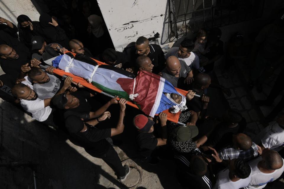 Palestinians carry a man's body during a West Bank funeral.