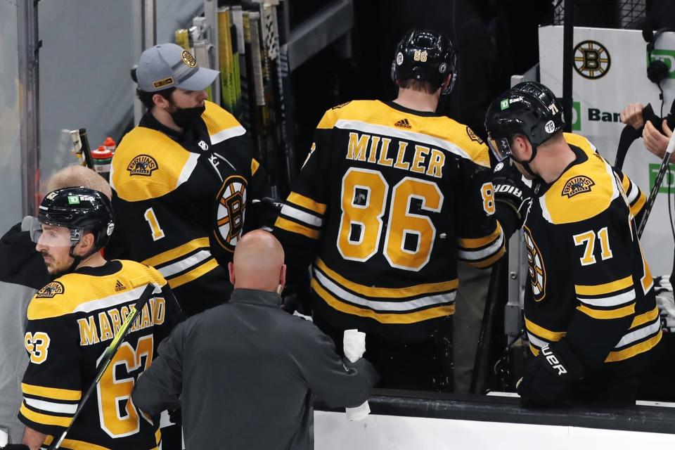 Boston Bruins' Kevan Miller (86) leaves the game after taking a hit from Washington Capitals' Dmitry Orlov during Game 4 of an NHL hockey Stanley Cup first-round playoff series, Friday, May 21, 2021, in Boston. (AP Photo/Michael Dwyer)