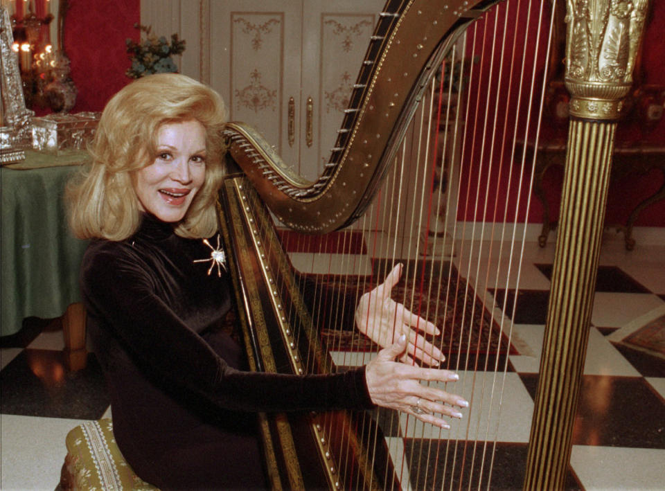 FILE - In this Tuesday, Dec. 12, l995 file photo, Phyllis McGuire, the youngest of The McGuire Sisters, plays a harp at her home in Las Vegas. Phyllis McGuire, the last surviving member of the three singing McGuire Sisters who topped the charts with several hits in the 1950s, has died, Tuesday, Dec. 31, 2020. She was 89. (AP Photo/Lennox McLendon, File)