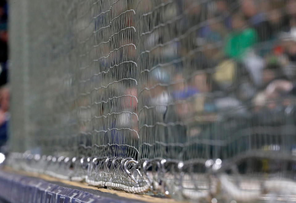 Newly installed netting at Safeco Field designed to protect fans from foul balls and flying bats is shown above the visitors’ dugout during a game between the Seattle Mariners and the Cleveland Indians on Thursday in Seattle. (AP)