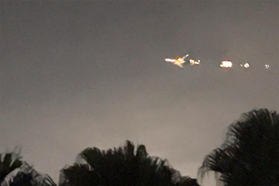 This image taken from video provided by Melanie Adaros shows sparks shooting from a cargo plane before making an emergency landing at Miami International Airport on Thursday, Jan. 18, 2024 in Miami.