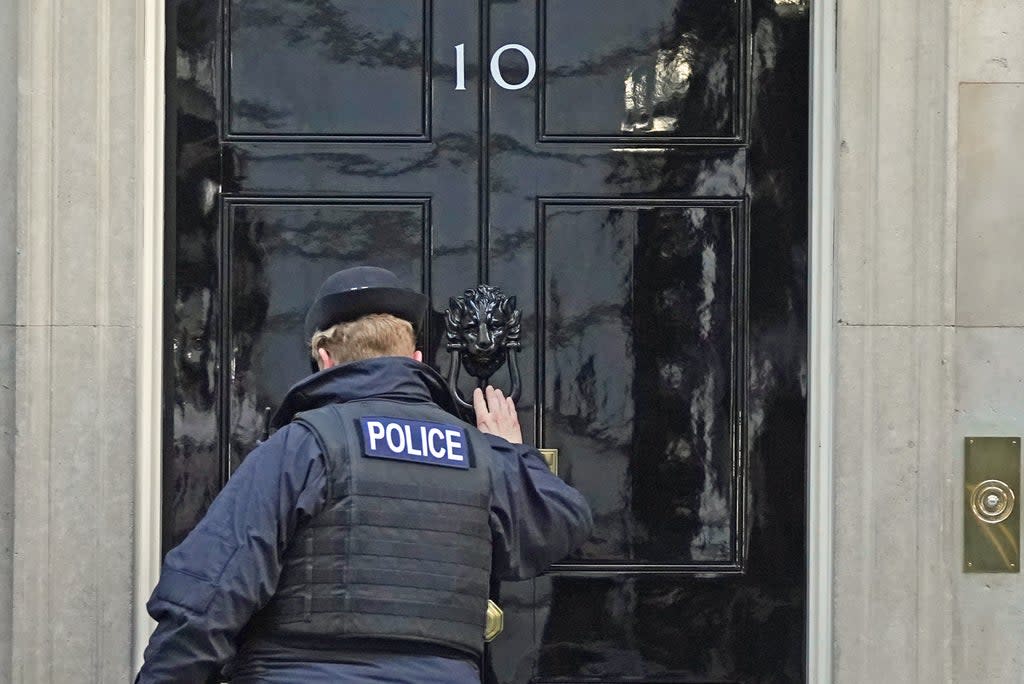 A police officer knocks on the door of the Prime Minister’s official residence in Downing Street (Stefan Rousseau/PA) (PA Wire)