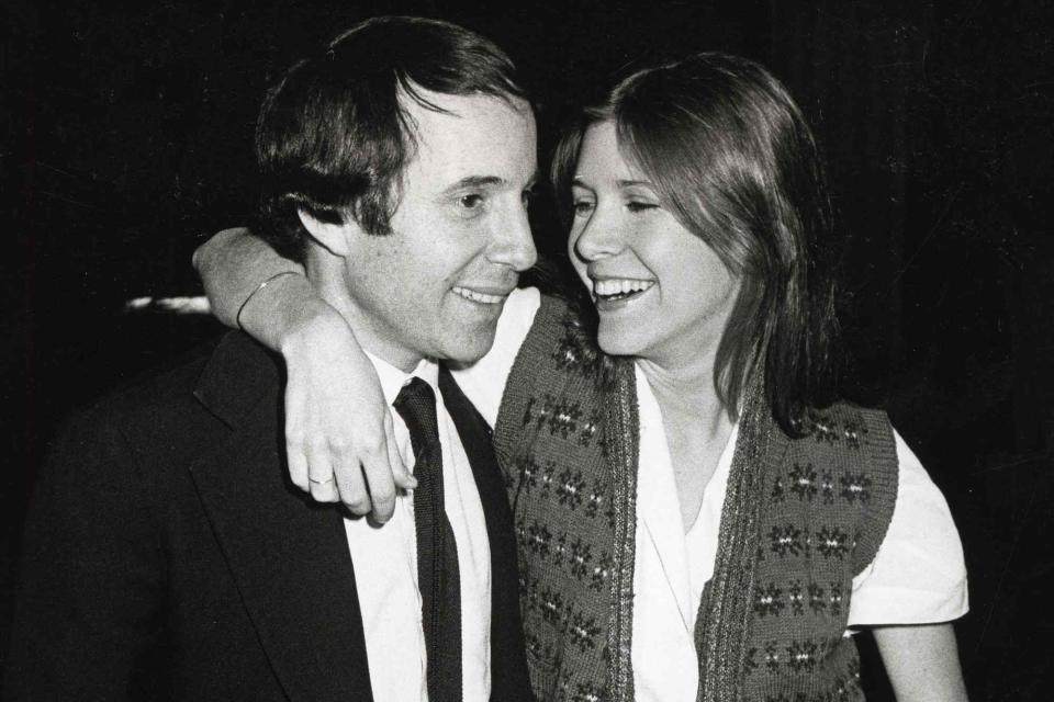 <p>Ron Galella Collection via Getty</p> Paul Simon and Carrie Fisher at the premiere of the 1984 film 